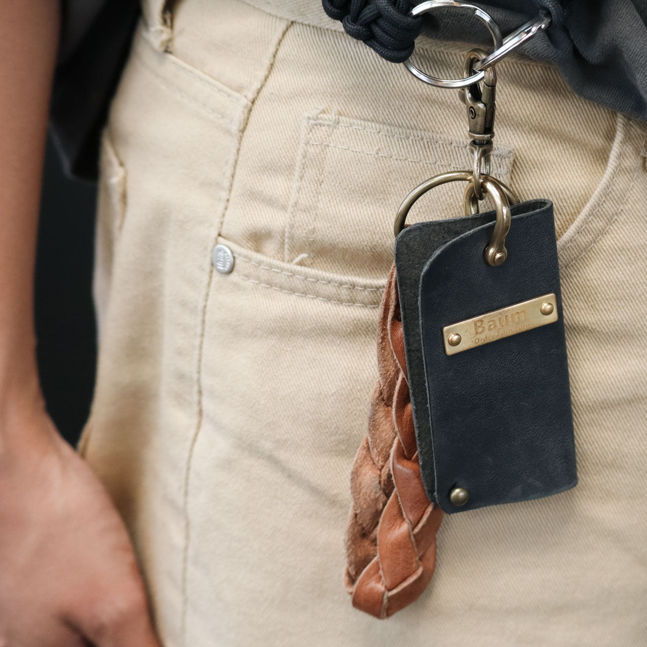 携帯ストラップにつけたレザーキーケース(ブラック)とレザーキーホルダー(オレンジ)