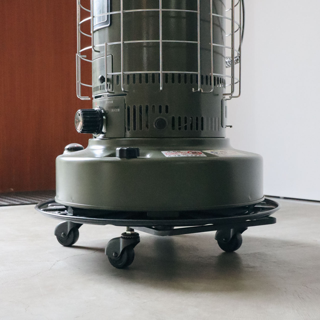 大きいストーブをスクエアアイアンプレート台車にのせて押して移動している様子 寄り